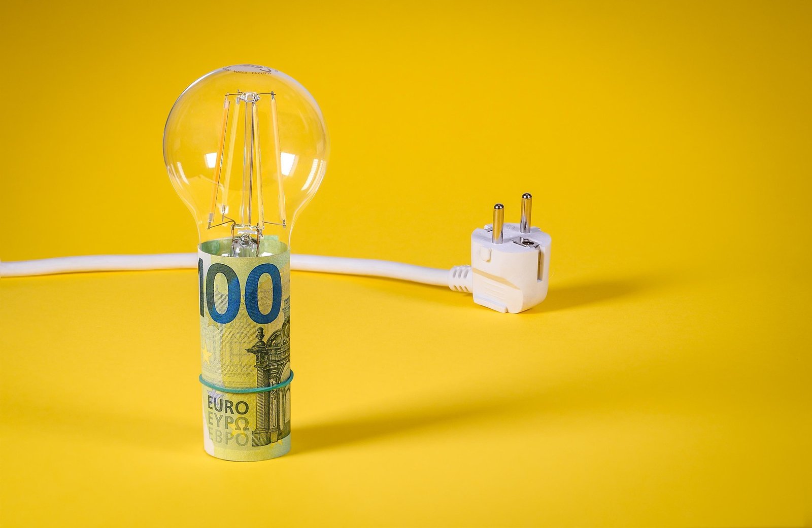 Persona feliz revisando su factura eléctrica reducida tras aplicar consejos de ahorro energético