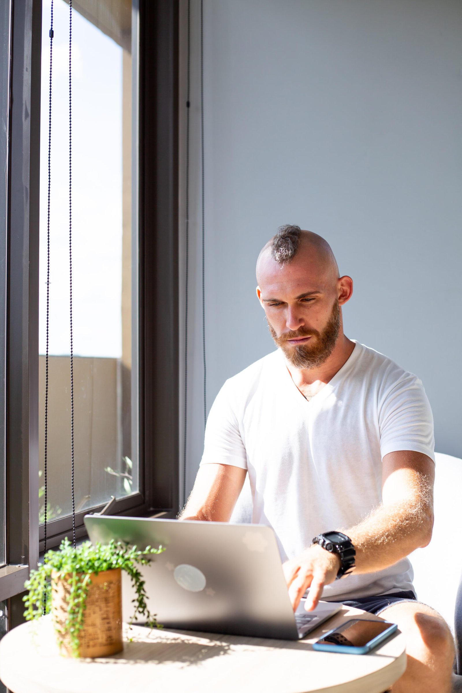 Profesional trabajando en laptop en una oficina moderna, concepto de productividad empresarial y tecnología en la nube.