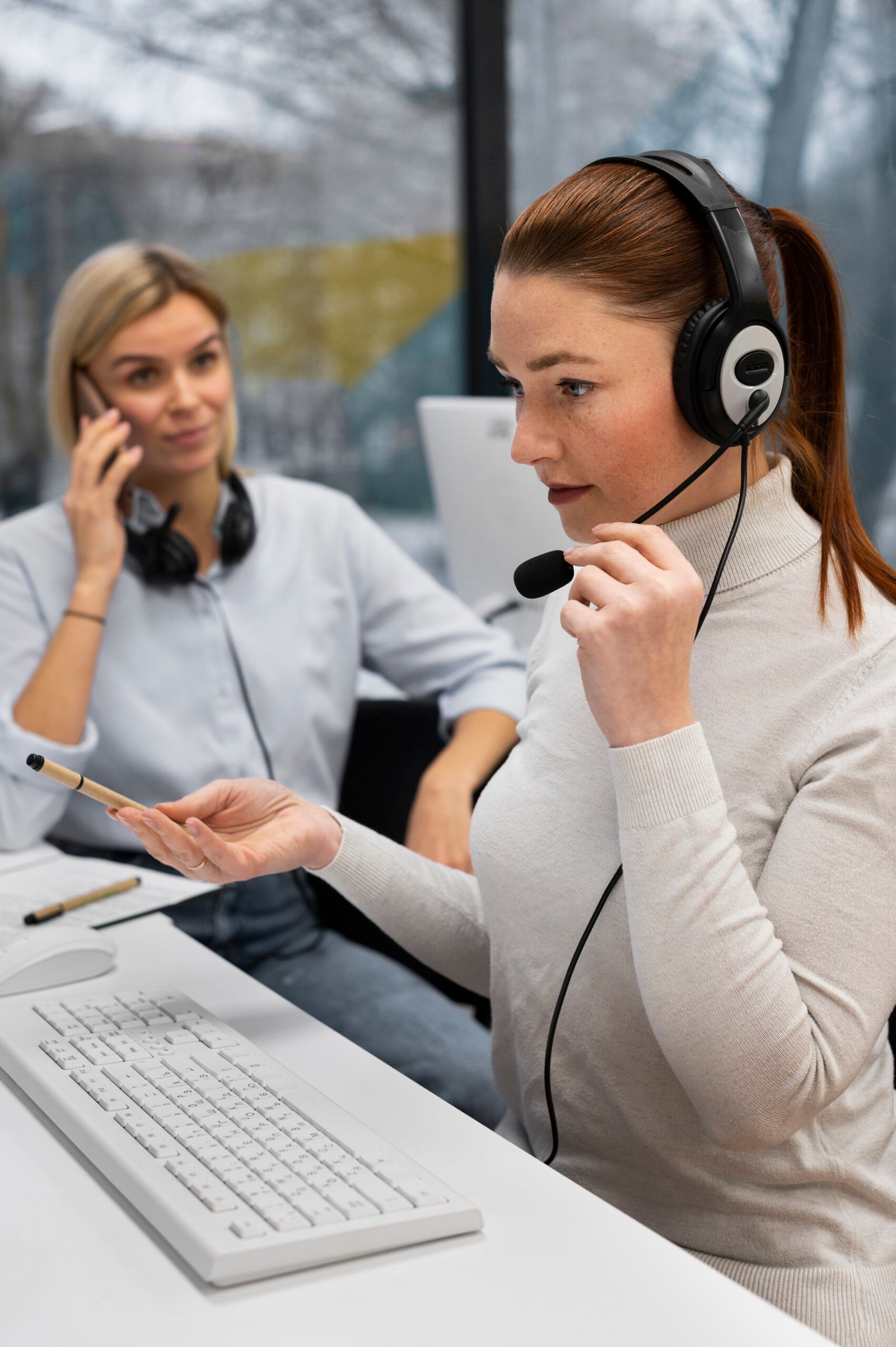 Business team using cloud-based virtual phone system with headsets and laptops, working remotely in a modern office environment.